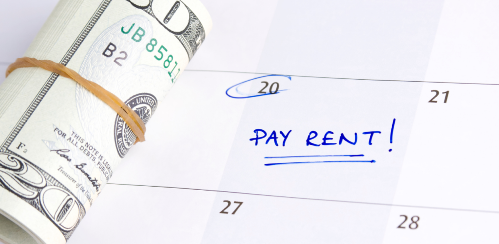 Property Management Rolled-up $100 bill beside a calendar with “Pay Rent!” marked on the 20th, symbolizing rental assistance and budgeting needs