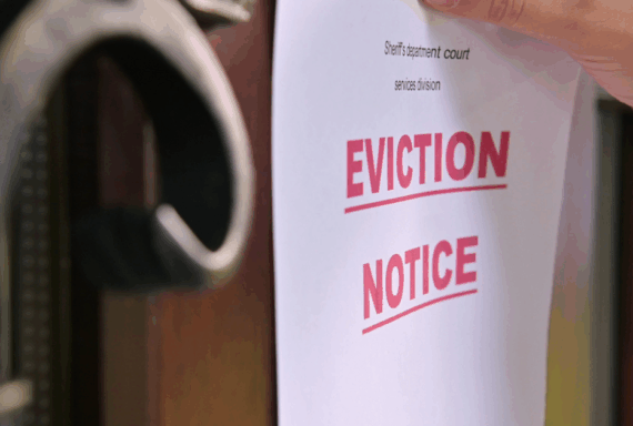 Eviction notice being posted on a wooden door by hand