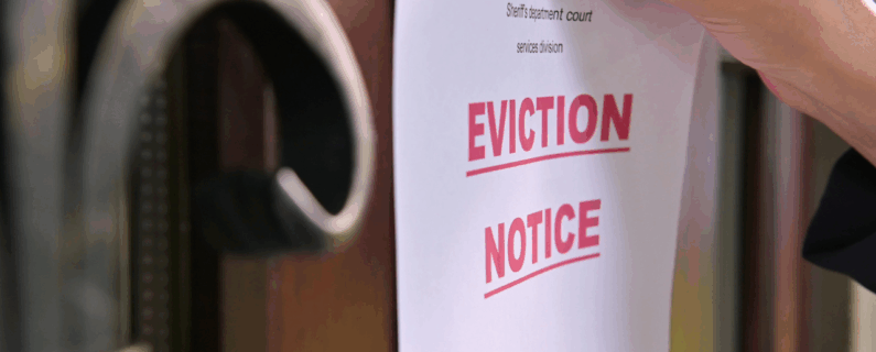 Eviction notice being posted on a wooden door by hand