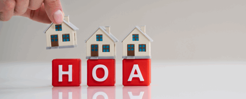 Mini houses placed on red blocks spelling HOA symbolizing homeowners association
