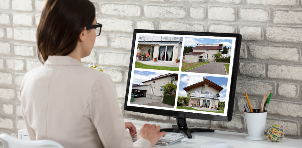 Woman viewing property photos on a computer monitor, showing four images of different houses