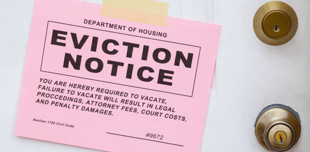 Pink eviction notice taped to a white door, warning tenant of legal action for failure to vacate