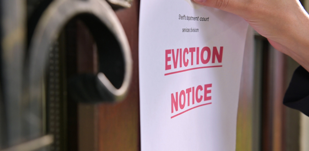Eviction notice being posted on a residential door, highlighting a challenging aspect of property management involving legal procedures and tenant accountability