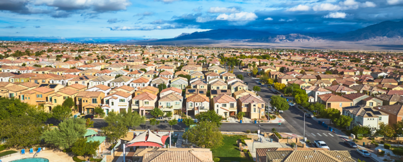 Aerial view of suburban housing community with rows of homes, highlighting residential real estate development