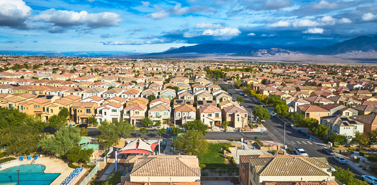 Aerial view of suburban housing community with rows of homes, highlighting residential real estate development